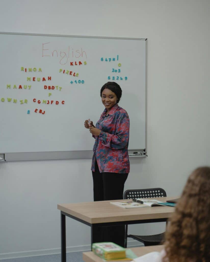 Teach standing in front of dry erase board